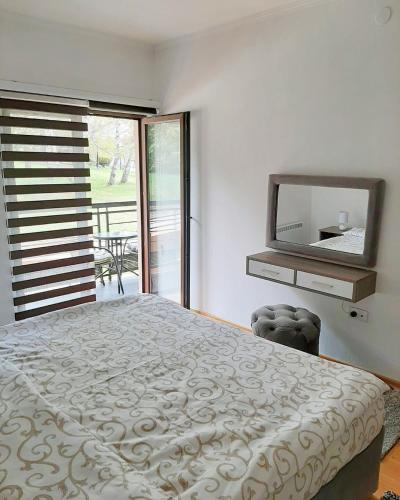 a bedroom with a large bed and a mirror at Zova Deluxe Apartment in Zlatibor
