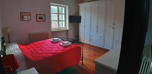 1 dormitorio con cama roja y ventana en Abruzzo - Teramo tra Mare e Monti con piscina, en Teramo