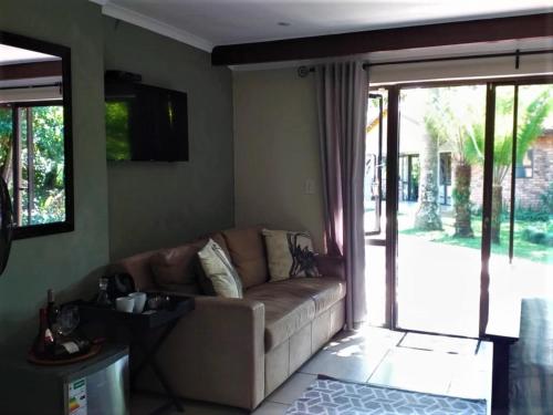 a living room with a couch and a sliding glass door at Matusadona Guest Lodge in Hillcrest