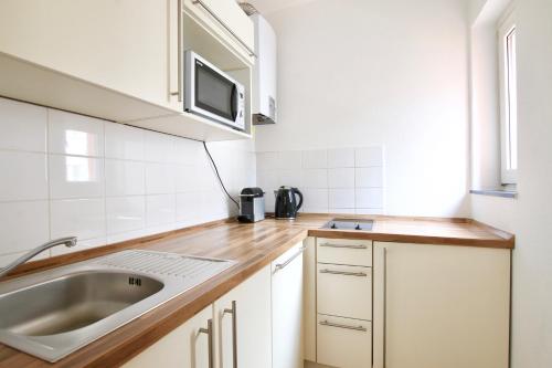 a kitchen with a sink and a microwave at Arthouse Apartments im Belgischen Viertel in Cologne