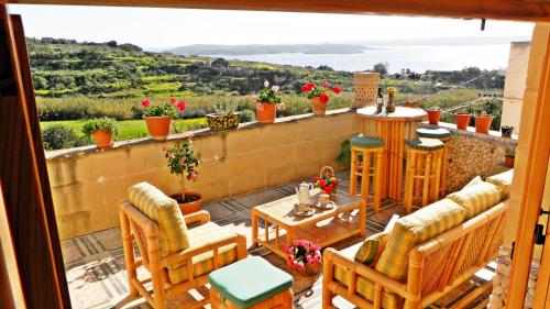 a balcony with chairs and a view of the ocean at Great Seaviews Location - FREE Gozo taxi service, Fast WIFI, Bicycles, BBQ & Parking, No Car needed in Għajnsielem
