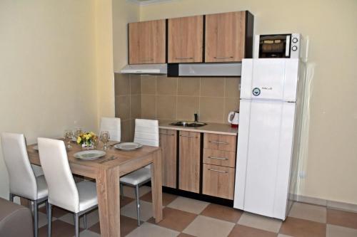 a kitchen with a table and a white refrigerator at Anvers Apartments in Sozopol