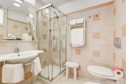 a bathroom with a shower and a sink and a toilet at Hotel Europa Beach Village in Giulianova