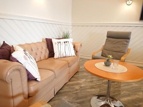 a living room with a couch and a table at Övik Eventhotell in Örnsköldsvik