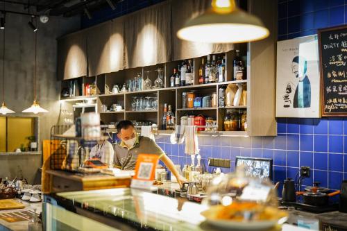 a man behind a counter in a restaurant kitchen at Cheng Zhai in Hangzhou