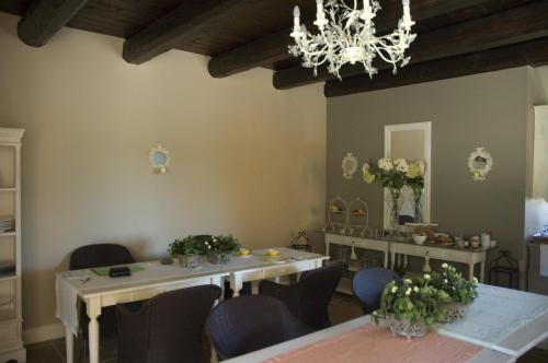 a dining room with tables and chairs and a chandelier at Country House Il Sassòne in Camerano