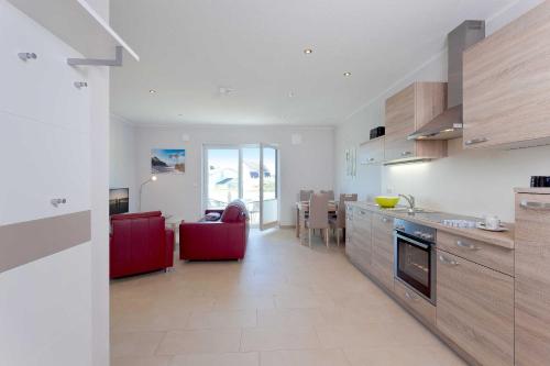 una cucina e un soggiorno con divano rosso e tavolo di Ferienwohnung Bug a Zinnowitz