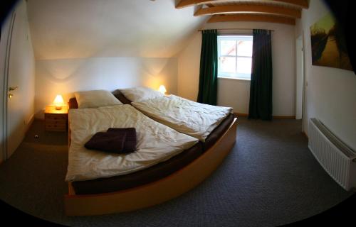 a bedroom with a large bed with white sheets and a window at Ferienhaus Seegasse 4 in Göhren-Lebbin