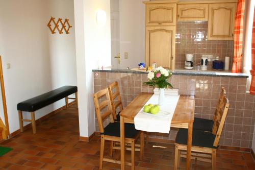 a kitchen with a wooden table and chairs with a vase of flowers at Ferienhaus Seegasse 4 in Göhren-Lebbin