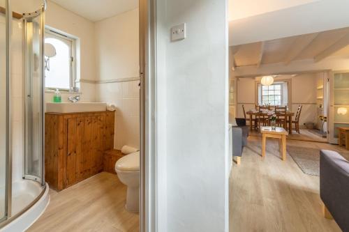 a bathroom with a tub and a toilet and a dining room at Porthgwidden Cottage in Uny Lelant