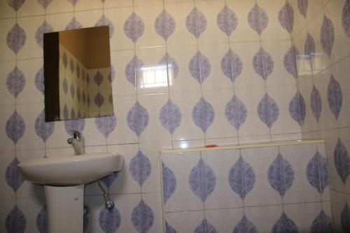 a bathroom with a sink and a mirror at Pride Travellers Hotel Mubende in Mubende