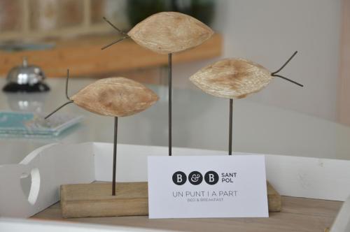 three hats on sticks on a table with a sign at B&B Sant Pol - Adults Only in San Pol de Mar