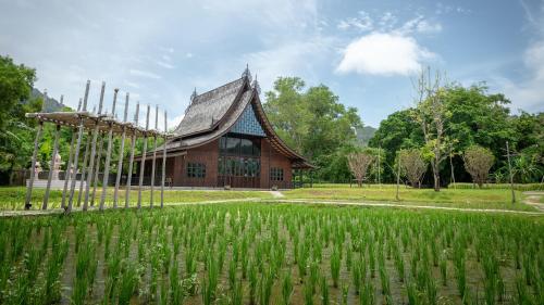 a large building with a grass field in front of it at Hotel Indigo Phuket Patong by IHG in Patong Beach