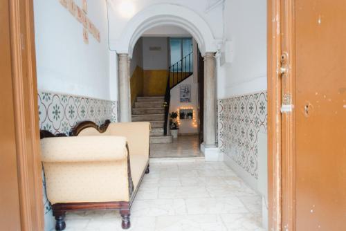 a living room filled with furniture and a stairway at Hostal Vidamia in Málaga
