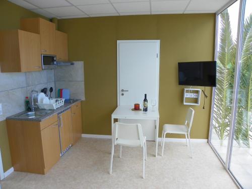 a kitchen with a table and two chairs and a tv at Casa-Palo-Pique in Icod de los Vinos