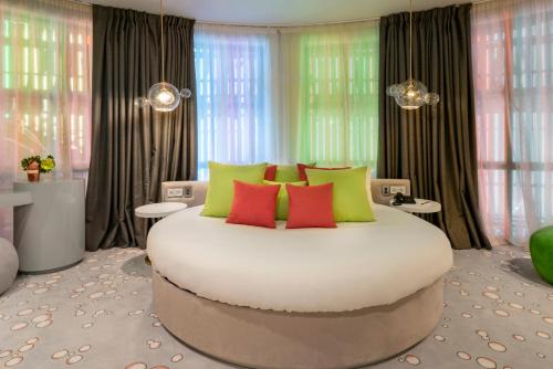 a bedroom with a large white bed with colorful pillows at Vincci Capitol in Madrid