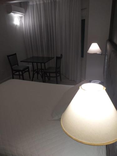 a hotel room with a bed and two tables and chairs at Hotel Solaris in São Miguel dʼOeste