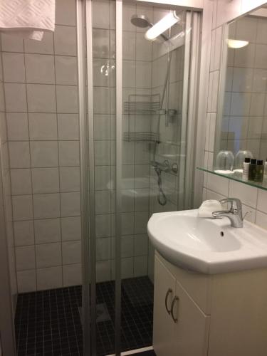 a bathroom with a shower, sink, and mirror at Darby's Inn in Stavanger