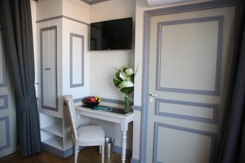 a door leading into a room with a desk and a vase of flowers at Hôtel Villa-Lamartine in Arcachon