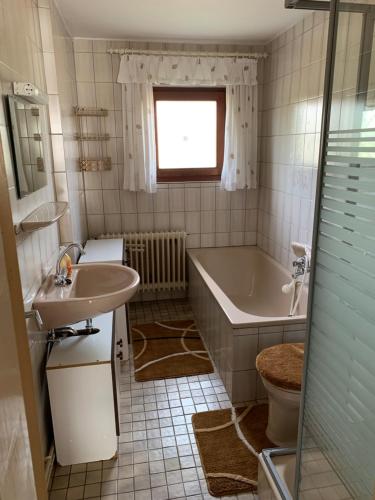 ein Badezimmer mit einer Badewanne und einem Waschbecken in der Unterkunft Ferienwohnung Duensing in Neudorf