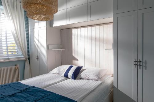 a small bedroom with a bed with white cabinets at Apartamenty Latarnia Morska – Sun Seasons 24 in Kołobrzeg