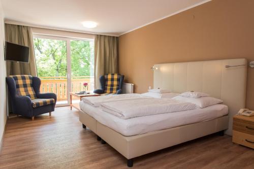 1 dormitorio con 1 cama grande y 2 sillas en Der Seewirt en Franking