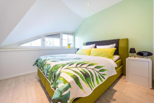 - une chambre dotée d'un lit avec un couvre-lit vert et jaune dans l'établissement Ferienhaus Seeblick, à Binz