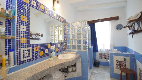 een blauw betegelde badkamer met een wastafel en een spiegel bij Casa de Campo Los Cipreses in Salobreña