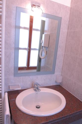 a bathroom with a sink and a mirror at Pilgrim's Hotel in Cicognolo