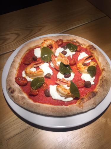 a pizza sitting on top of a plate on a table at BASE CAMP alpine apartments in Breuil-Cervinia