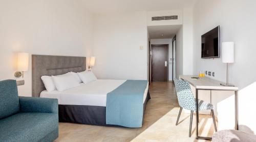 a bedroom with a bed and a chair and a table at Ilunion Calas de Conil in Conil de la Frontera