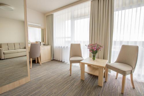 a room with two chairs and a table with flowers on it at Centrum Zdrowia i Wypoczynku Ikar in Kołobrzeg