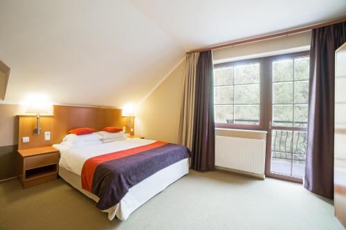 Un pat sau paturi într-o cameră la Hotel Korona Park Klewinowo