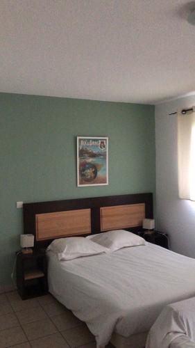 a bedroom with a bed and a green wall at Résid'Artel Cadarache - ITER in Saint-Paul-lez-Durance