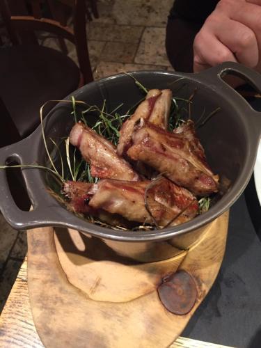 a pan filled with meat on top of a wooden board at BASE CAMP alpine apartments in Breuil-Cervinia