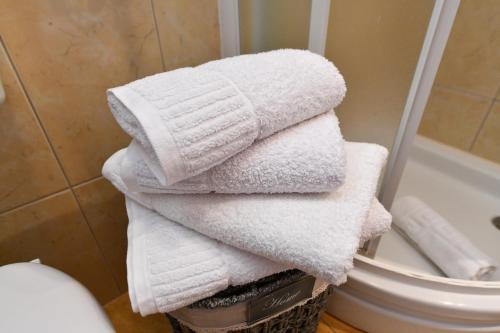 a pile of towels in a basket in a bathroom at Apartments Vila Miranda in Vodice