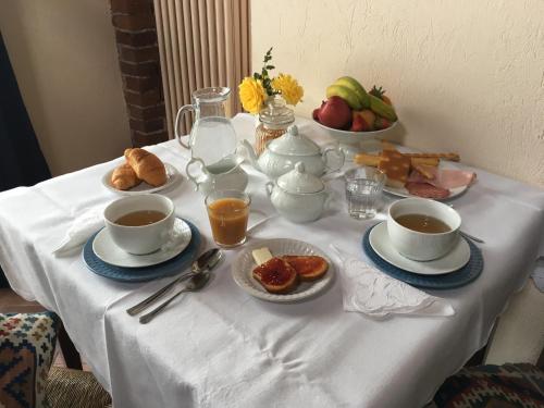 een tafel met kopjes en schotels koffie en eten bij B&B Gira-Sole in Cuneo