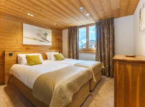 um quarto com 2 camas e um tecto de madeira em Alaska Lodge em Morzine