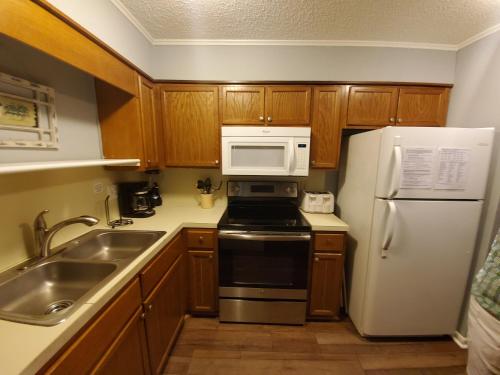a kitchen with a white refrigerator and a microwave at Winterplace Condos - Ski In Ski Out! E101 in Ghent