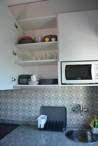 a kitchen counter with a sink and a microwave at Casa da Avenida in Póvoa de Varzim