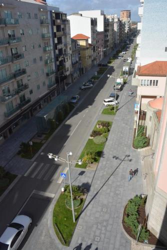 an empty city street with cars parked on the road at Casa da Avenida in Póvoa de Varzim