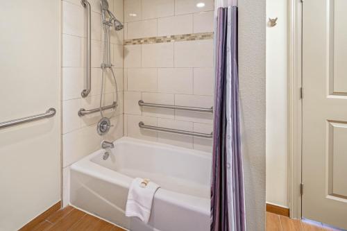 岡薩雷斯的住宿－岡薩雷斯拉昆塔套房酒店，带淋浴的浴室配有白色浴缸。