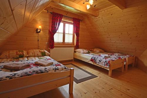 1 Schlafzimmer mit 2 Betten in einem Blockhaus in der Unterkunft Domek Góralski U Hanki Domek przy Stoku in Małe Ciche