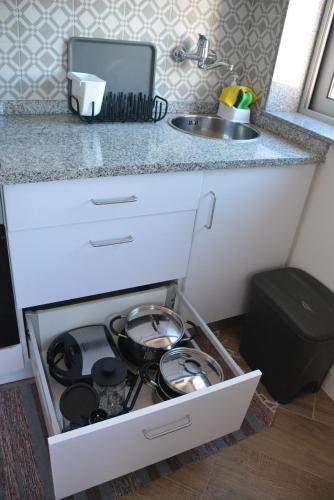 a kitchen drawer with pots and pans in it at Casa da Avenida in Póvoa de Varzim