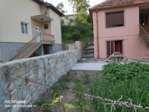 a house and a stone wall next to a building at Apartman Pavle Virpazar in Virpazar