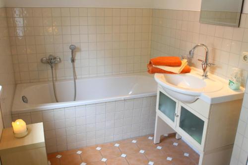 a bathroom with a tub and a sink and a bath tub at Ferienhaus Seegasse 4 in Göhren-Lebbin