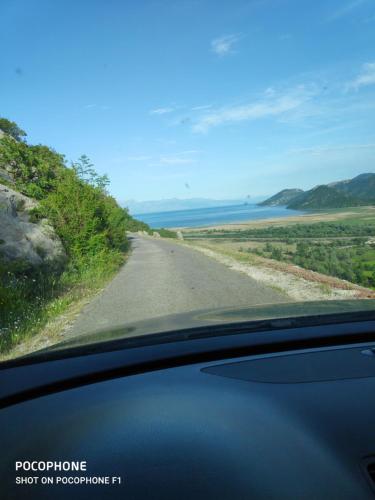 a road with a view of the ocean from a car at Apartman Pavle Virpazar in Virpazar