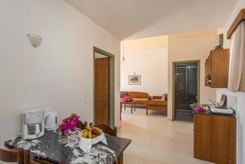 a kitchen with a counter with a bowl of fruit on it at Stefan Village Hotel in Agia Marina Nea Kydonias