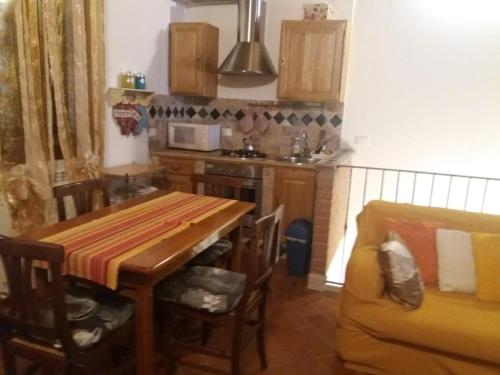 a kitchen with a wooden table and a couch at PALLADIO appartamento turistico in Rovigo