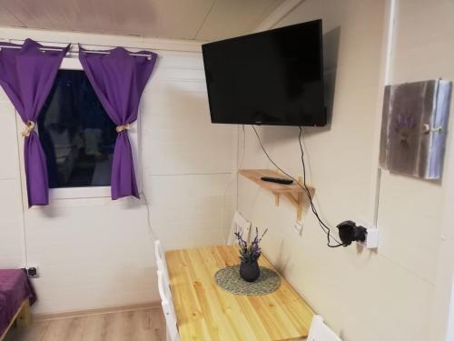 a room with a table and a tv on a wall at Miodowy Zakątek Całoroczne Domki i Pokoje przy Suntago, Deepspot, Pyszne Śniadania, Grill in Mszczonów